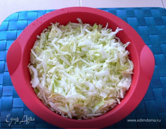 Капусту мелко нашинковать, помять руками и выложить в силиконовую форму