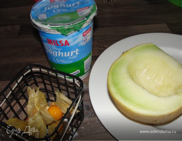 Очистить половинку небольшой дыньки, порезать кубиками. Залить йогуртом и медом. 
Фисалис помыть, почистить.
Уложить сверху.
