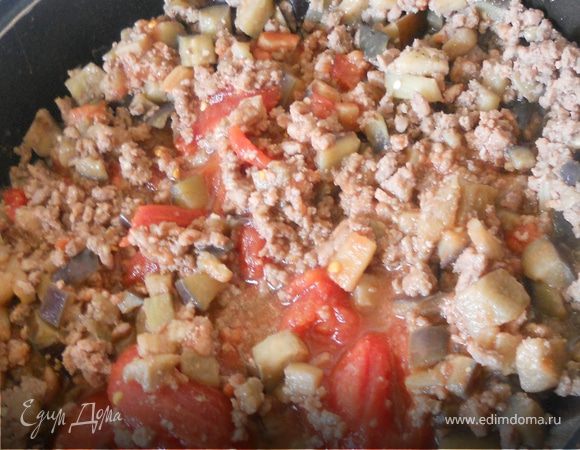 Присоединить к баклажанам и фаршу томаты вместе с жидкостью (1 банку) и оставить на достаточно сильном огне на несколько минут, чтобы лишний сок выпарился. Огонь выключить, остудить.