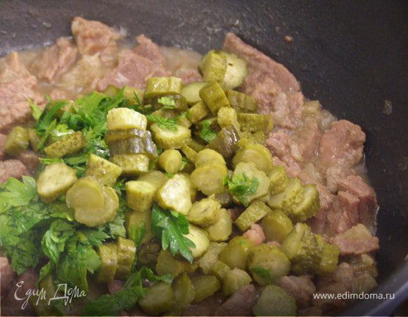 Добавляем мелко порезанную зелень и корнишоны. Накрываем крышкой и даем потомиться минут 5.