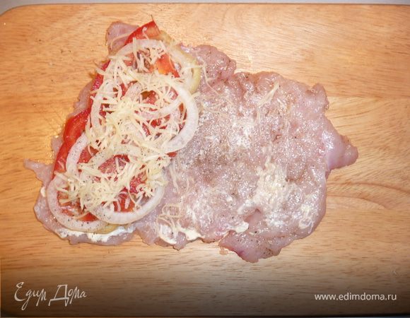 "Упаковываем" конвертик: грудку кладем гладкой стороной вниз, на половинку выкладываем слоями: перец, помидоры, лук, солим, перчим, присыпаем тертым сыром. 