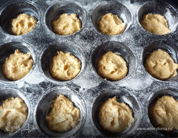 Форму для маффинов смазать маслом и присыпать мукой. Выложить тесто и запечь в духовке 10 минут.
