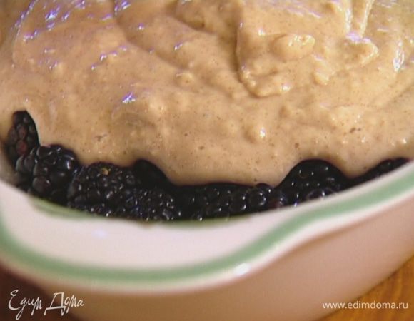 Керамическую форму смазать растительным маслом, выложить ежевику, сверху равномерно распределить тесто.