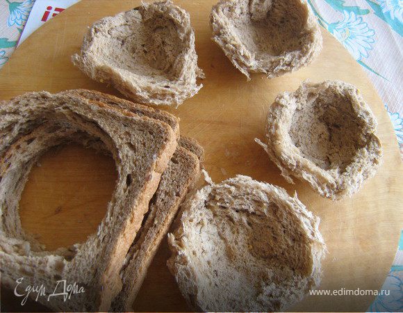 Вырезать стаканом из куска хлеба круг,выложить хлебными кружочками формочки для маффинов или тарталеток.Изнутри,хорошо прижать к стенкам
