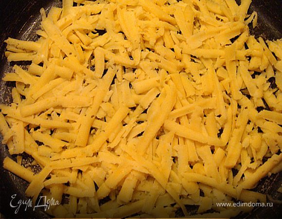 Итак. Приготовим корзиночку из сыра. Для этого: натрем половину сыра на терке крупной.
Выкладываем сыр на сковородку,распределяем по дну и ставим на огонь. прожариваем до расплавления и небольшого зарумянивания. Минуты 3-5 это займет. Главное,чтоб сыр припекся немного как блинчик и его можно было легко поддеть лопаткой и перенести на форму