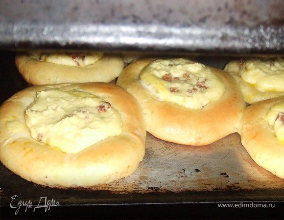 Смешать дрожжи с небольшим кол-вом теплого молока и сахара. Дайте подняться 10 минут. Масло растопить, смешать с молоком, сахаром и солью...Добавить яйца. ВВести в опару и добавить просеянную муку. Замесить эластичное тесто. Положить в миску, затянуть пленкой и оставить в теплом месте подходить 1,5 часа...

Смешать все ингридиенты для начинки.

Тесто разделить на 14-16 колобков, каждый раскатать в лепешку, толщиной в 1 см. Выложить на противень,выстланный бумагой для выпечки и оставить подходить 30 минут. Затем в каждой лепешке сделать углубление дном стаканы и положить туда творожную начинку...Выпекать при 180 градусах около 15 минут...