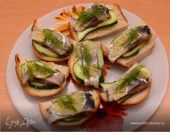 На хлеб тонким слоем намазать горчицу, положить огурец, затем сельдь, лимончик. Украсить зеленью (укропом).Приятного аппетита!