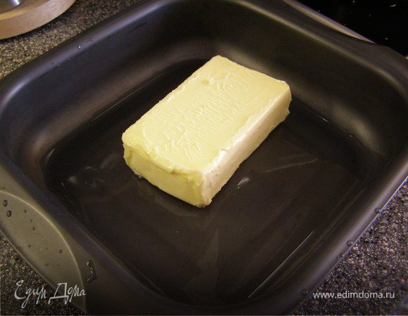 Духовку разогреть до 200 градусов. В форму положить 1 пачку масла и поставить в духовой шкаф.