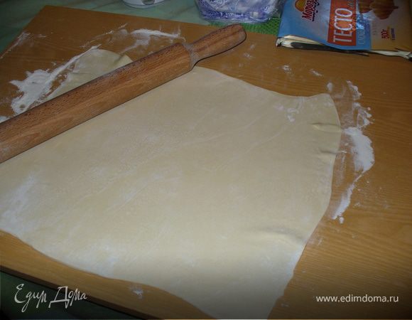 Смазать кусочком сливочного масла бумагу для выпечки, застелить форму. Раскатать пласты слоеного теста, выложить один на дно формы, так, чтобы получились высокие бортики.