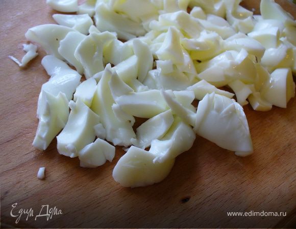 Яйца остудить под холодной водой, почистить, отделить белки от желтков. Белки крупно порубить, отправить в миску