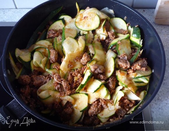 Добавить томат-пасту, приправить солью и перцем. Добавить кабачки, перемешать.