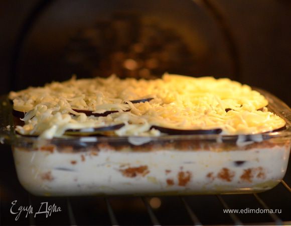 Перемешать молоко, сливки, яйцо, тертый мускат орех, соль, перец и вылить половину этой смеси на мусаку. Затем снова выложить картофель, оставшийся фарш и баклажаны, вылить оставшийся соус и посыпать тертым сыром. Запекать в духовке при 200 С около 50 минут. Если сверху будет сильно румянится, то накрыть фольгой.