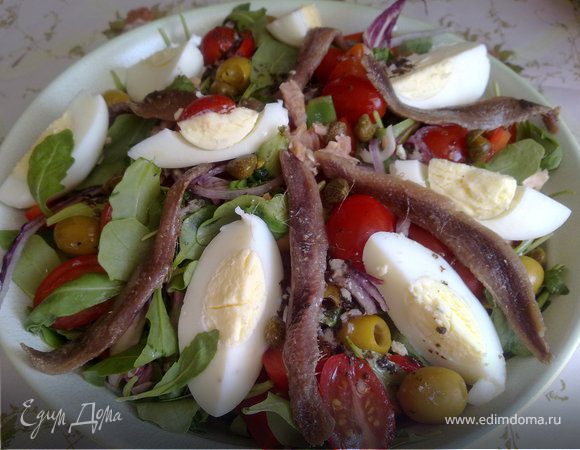 Салат разобрать на листья, помыть, высушить - большие листья порвать в миску.
Помидоры разрезать пополам вдоль, потом каждую часть на 2 или на 3. Сварить яйца, порезать молодой лук. Маслины, если крупные, хорошо промыть от масла и разрезать пополам. Если мелкие - целиком. Сладкий перец почистить и порезать тонкими ломтикам. Огурец порезать тонкими ломтиками. Яйцо почистить и порезать на четвертинки. Анчоусы, если очень соленые промыть или вымочить.

В салатник, расширяющийся "к верху" выложить: 
- слой салата
- слой лука
- слой помидор
- фасоль и перец
Повторить слои несколько раз. Перемешать вилкой винегрет, попробовать, посолить-поперчить по вкусу и залить салат. Перед подачей на салат выложить тунец, яйца четвертинками, маслины, каперсы и анчоусы. Еще раз поперчить и слегка сбрызнуть лимонным соком. (Тунец я выкладывала слоем за луком). 
