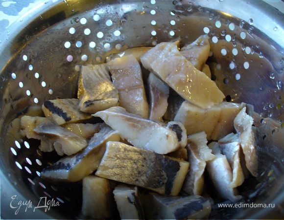 Нарезать филе сельди на кусочки. Можно взять (а может, даже лучше, а плане полного отсутствия косточек) готовое филе в масле (но без добавок, просто в масле). Каюсь, взяла готовую, а если вы не ленивец, как я, берите свежезасоленную селедку, чистите ее и режьте. У вас получится вкуснее, чем у меня. Почистить, откинуть на дуршлаг, чтобы стекло масло. Если у вас всё же свежезасоленная селедка, на дуршлаг ее откидывать необязательно)