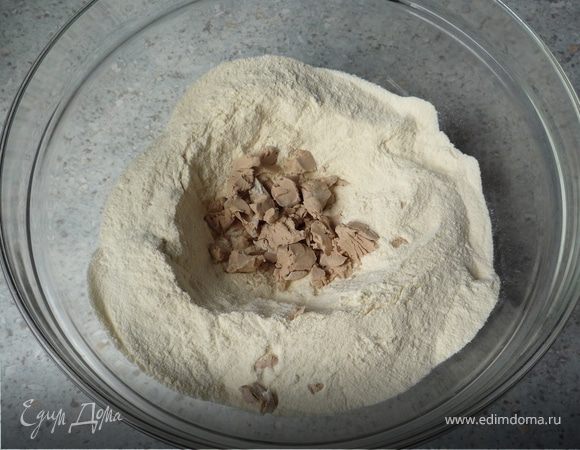 Подогреть молоко. Муку положить в емкость, посреди сделать небольшую лунку. Положить в нее дрожжи, посыпать 50г сахара и залить половиной молока. Размешивать пока дрожжи полностью не растворятся.