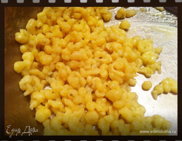 силиконовой лопаткой выкладывать небольшие порции теста прямо в дуршлаг и "протирать" тесто сквозь дырочки дуршлага. таким образом тесто попадает прямо в кипяток. Снимаем дуршлаг с кастрюли и оставляем спацлы вариться 1 минуту. Снимаем шумовкой и отправляем в мисочку с расплавленным сливочным маслом.