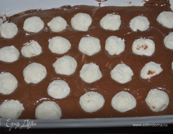 Форму 15Х25 смазать маслом и посыпать мукой. Вылить половину теста. 
В оставшуюся половину теста добавить какао и молоко. Хорошо перемешать.
Аккуратно вылить на белое тесто и ровно распределить.
Сверху уложить кокосовые шарики.