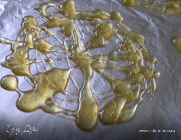 Затем сделать карамельную паутинку. Для этого смазать фольгу маслом и вылить на нее тонкие струйки карамели. Когда карамель остынет, её легко можно будет снять с фольги.