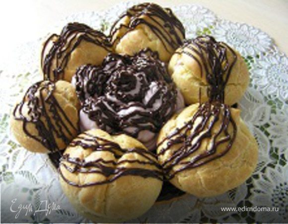 Затем крем и профитроли залить с помощью шприца оставшимся ганашем. В центр торта поместить карамельную паутинку.