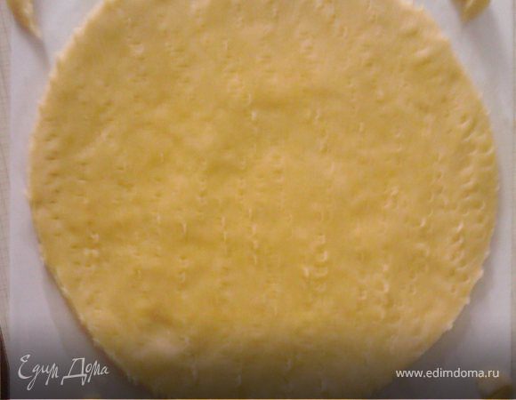 Включаем духовку на 180-200 градусов, немного прогреваем. Раскатываем тесто на пергаменте (у меня обычная бумага А4, понадобилось 2 листочка). Прикладываем тарелку нужного диаметра, обрезаем по краю. Обрезки оставляем на листе. Часто – часто накалываем весь корж и отправляем в духовку на 13-15 минут.
Следите, чтобы коржи не подгорали! Пока первый печется, раскатываем следующий корж на бумаге. 1 лист можно использовать 4-5 раз. Часто накалывать корж вилкой нужно для того, чтобы он выпекся ровным, а не вздулся пузырями. 
   Горячий корж сразу снимаем с противня и переворачиваем вверх дном на ровную поверхность для остывания. После остывания можно складывать коржи друг на друга. 
   Остывшие обрезки измельчаем в крошку.
   Фото коржей будут в шаге № 4.