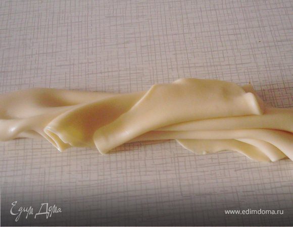 ШОКОМАСТИКА.
Плитку шоколада 100 г ломаем на очень мелкие кусочки – каждую дольку где-то на 4 части. 1/3 поломанного шоколада отставляем в сторону. 2/3 выкладываем в чашку. Чашку ставим на водяную баню так, чтобы вода не касалась дня чашки (у меня: на кастрюльку ставим дуршлаг, а на него чашку). Ставим всю конструкцию на плиту и растапливаем шоколад, постоянно помешивая. Как только вода начинает кипеть, снимаем чашку с шоколадом с водяной бани. Шоколад нельзя топить при температуре выше 37 градусов, иначе он сварится, и ничего у нас не получится. Примерно к этому моменту он уже почти растопился, может остаться несколько мелких кусочков. Высыпаем в чашку оставшиеся 1/3 шоколада и хорошо размешиваем до растворения. В эту массу добавляем 2 ст.л. подогретого меда, размешиваем ложкой до загустения. Густеть начинает сразу же, прямо на глазах. Полученную смесь хорошо вымешиваем руками до получения пластичной тянущейся массы. В процессе вымешивания выделяется довольно много какао-масла, поэтому лучше руки держать над какой-либо поверхностью или тарелочкой. Месить надо примерно минут 15. В конце, когда мастика уже тянется, просто вытягиваем ее в длину и складываем, и так несколько раз. Вот на этом фото видно, какая тягучая пластичная мастика получается.
Из этой мастики можно лепить, можно ее раскатывать, можно хранить в холодильнике. На вкус – как шоколадная ириска (с приятным медовым вкусом).