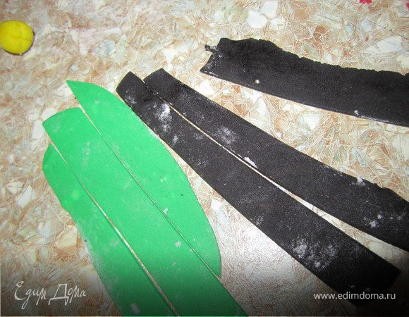 Раскатать зеленую и черную мастику. Нарезать полосками шириной 5-7 мм.