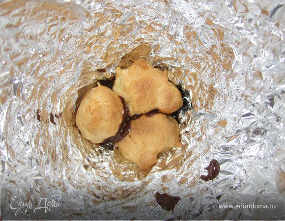 Растопить шоколад ( можно брать любой, очень интересно будет сочетание разного ...белого, черного и молочного, у меня дома, к сожалению, оказался только черный). Мокая бочек профитроля в шоколад складываем их в конус.