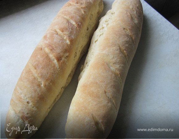 В теплую воду добавить дрожжи и сахар. 
Перемешать и подождать 10 минут.
Муку соединитель с солью, просеять. Влить опару. Вывесить тесто.
Накрыть готовое тесто и оставить на 2 часа.
Через два часа выкладываем тесто на стол, который посыпим мукой. Делим на две части. Каждую часть раскатываем скалкой в прямоугольник и сворачиваем в рулет. Делаем острым ножом семь надрезов. 
Поверхность багета можно посыпать мукой и тогда это будет хлеб по деревенски. Или можно смазать растительным маслом.
Даем отдохнуть 25 минут и ставим в разогретую до 220* духовку на 20-25 минут.
Когда хлеб испечется, остудите его на полотенце.
Приятного аппетита!