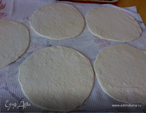 Каждый шар раскатать в лепешку и дать им отдонуть под полотенцем 10 минут.