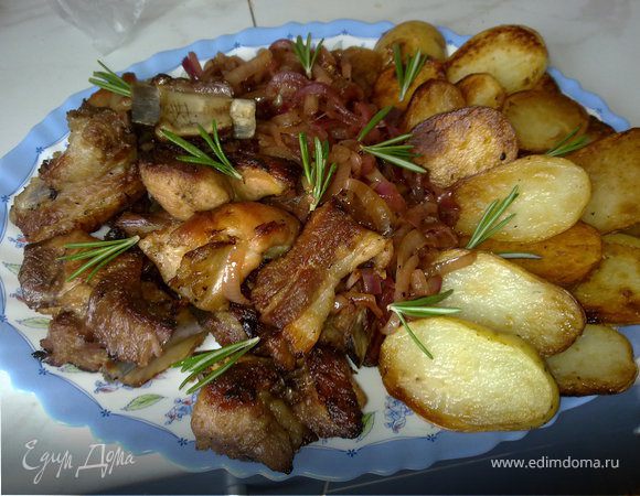 Выложить на блюдо ребра, лук и печеный картофель. Сверху  выложить листики розмарина. 