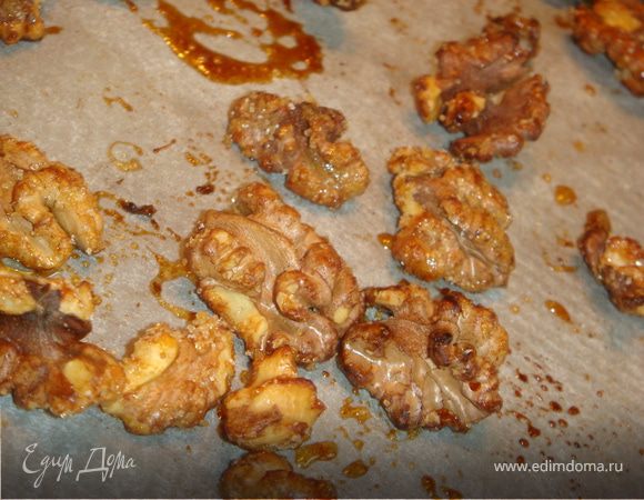 Грецкие орехи сбрызгиваем соком лимона, присыпаем сахаром и отправляем в духовку на несколько минут, сахар должен растаять и закарамелизоваться. Остывшие орехи порубить ножом на небольшие кусочки, оставить несколько штук целыми для украшения.