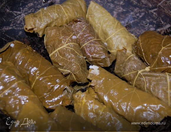 Заворачиваем в листочки наш фарш и укладываем на дно кастрюли или казана нашу долму. Очень вкусно добавить в кастрюлю при варке кусочки айвы, но если не сезон, то можно положить несколько долек лимона. Заливаем водой, ставим на огонь и варим.