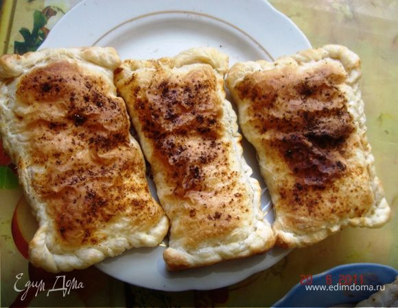 Раскатываем тесто и одну его часть (нижнюю) смазываем майонезом (сметаной) и томатной пастой.
Сверху кладём ломтики ветчины, которые чередуются один через один с сырками. Затем выкладываем яйца и лук. Посыпаем специями.
Закрываем верхней частью теста нашу слойку и заминаем тщательно все края, чтобы соус не вытек (иначе блюдо будет сухим...)
