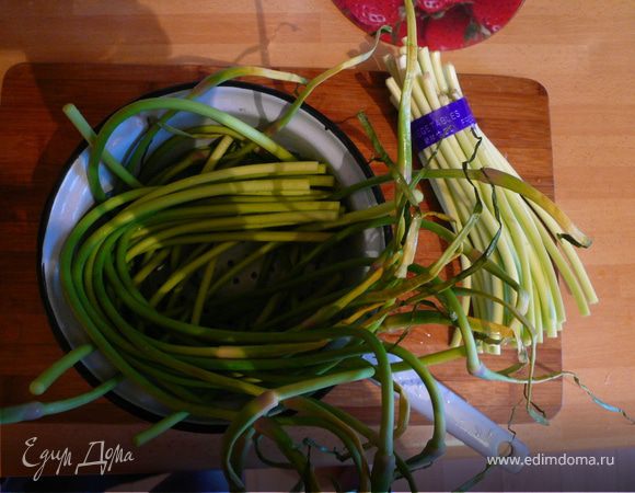 Подготовьте побеги чеснока. Для приготовления берите только темно-зеленую часть. Цветущие стрелки и нижнюю белую часть срежьте.