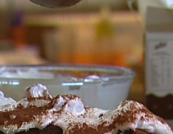 Переложить рулет на блюдо, отделить бумагу, украсить оставшимися взбитыми сливками с малиной, посыпать какао и отправить в холодильник.