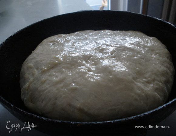 Смажем чугунную сковородку смальцем, положим наше тесто, смажем его смальцем, накроем полотенцем