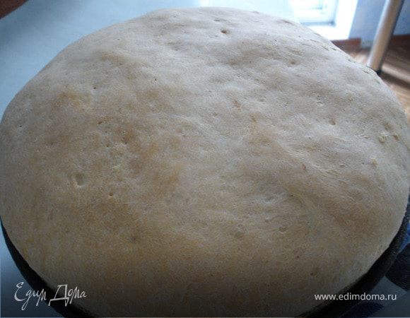 Разогреем духовку до 220*С, аккуратно помещаем сковороду с тестом в духовку и ставим на низ миску с водой.  Закрываем духовку и выпекаем хлеб до золотистого цвета минут 50-60.  Как только хлеб вынем из духовки сразу же смазать поверхность водой и накрыть полотенцем, пока хлеб не остынет.