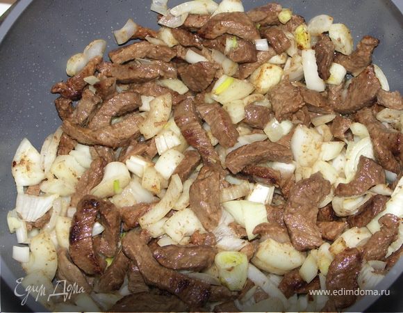 Добавить лук, нарезанный кубиками. Еще немного обжарить на среднем огне. Добавить тмин и чеснок.