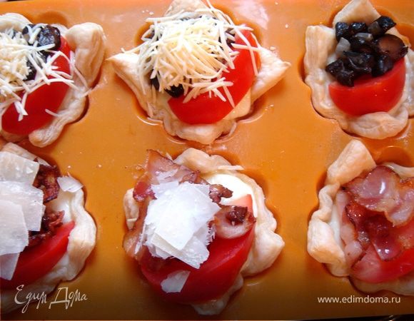 Тем временем подготовьте начинку.Для этого можно использовать всё,что любят ваши родные или друзья:обжаренный бекон,копчёное мясо,подсоленную рыбу,обжаренные с луком грибы,овощи,паштет и т.д.На готовые тарталетки выложите по дольке помидора и по ложке любимой начинки.Посыпьте пармезаном и моцареллой(или любым другим сыром).Сбрызьните тарталетки оливковым маслом и поставьте в духовку.Выпекайте до готовности сыра.Приятного аппетита!