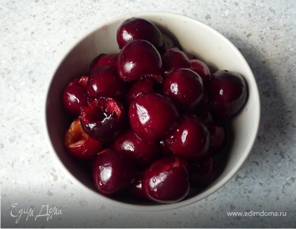 Разъемную форму выложить бумагой для запекания. Удалить косточки из вишни. Если вишня из банки, то слить сок. 