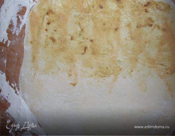 Чеснок готов. Очистите его и разомните вилкой до однородной массы. Присыпьте стол мукой и раскатайте тесто толщиной 0,5 см. одну чать теста намажте чесночной пастой. (поскольку мне показалось , что у меня чеснояной пасты маловато я присыпала еще сухим чесноком).