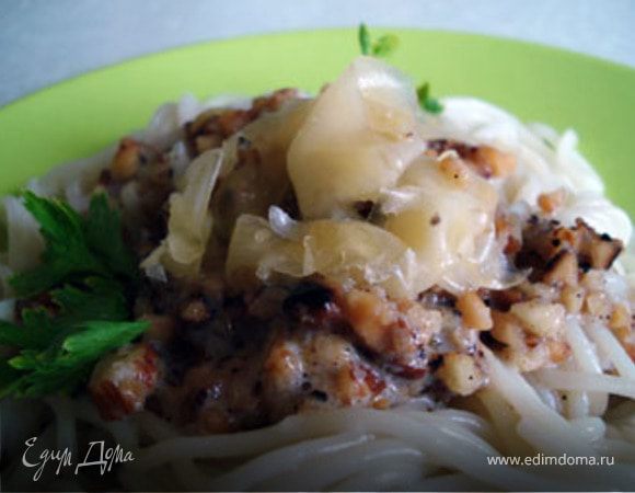 Спагетти выложить на тарелку. В центр положить орехи. Полить соусом. Украсить пластиночками сыра и петрушкой.