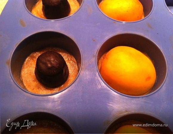 Достать формочки. На дно каждого пирожного положить конфету. Вторую часть я делала со свежими половинками абрикосов. 