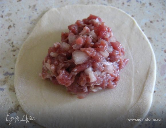 Готовое тесто делим на кусочки и раскатываем в круглые тонкие лепешки, примерно 10см. диаметром. Выкладываем фарш.