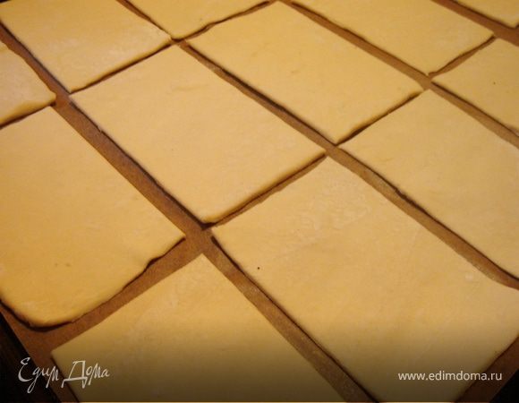 Пласт слоённого теста раскатать в прямоугольник 60х30см и разрезать на 18 прямоугольников 10х6см.