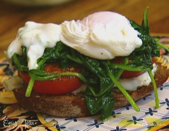 Выложить на каждый тост немного заправки из йогурта, половинки помидора срезами вверх и шпинат, сверху поместить яйцо пашот и еще немного заправки.