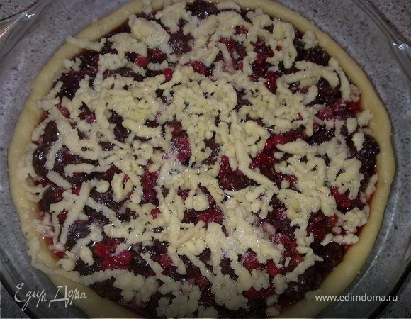 Достать застывшее тесто из морозилки и натереть его на терке сверху начинки. Можно посыпать сахаром. Выпекать при 180°C 30–35 минут.