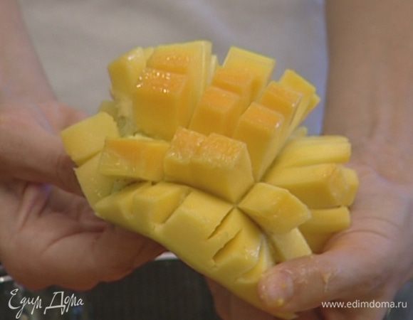 Манго разрезать пополам. Нарезав мякоть в «клеточку», вынуть ее ложкой.