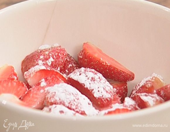 Клубнику крупно нарезать, посыпать оставшейся сахарной пудрой и листьями мяты.