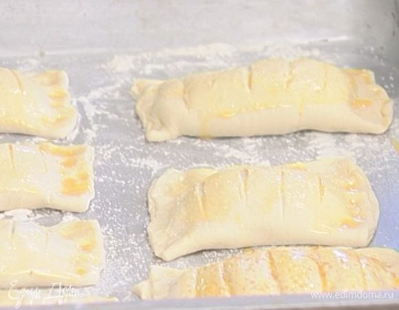 Яйцо слегка взбить и смазать поверхность булочек.